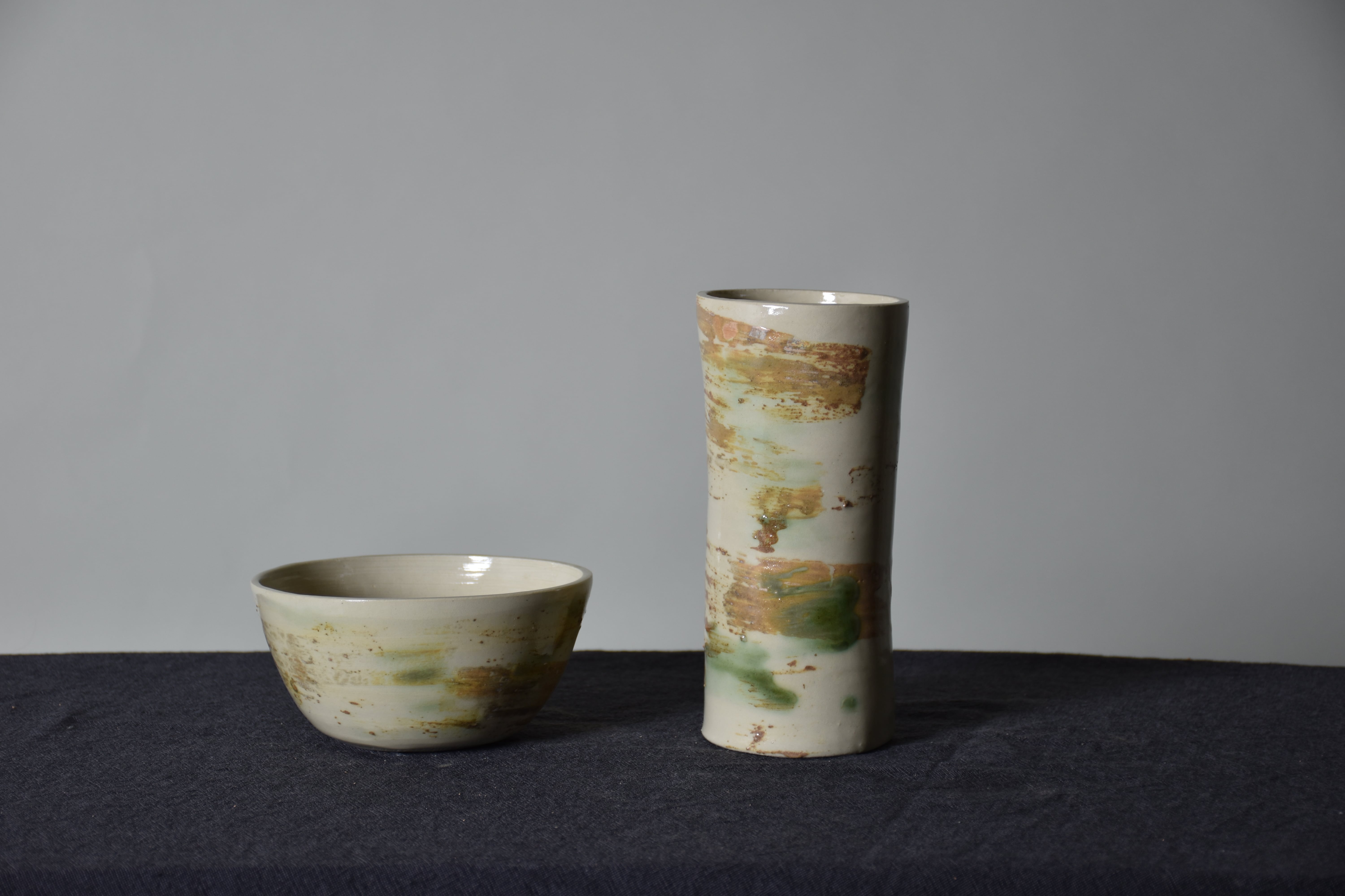 a grey clay bowl and flower vase on a table